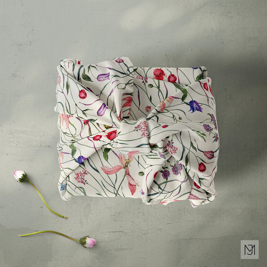 Botanical II pattern printed on fabric, folded and knotted into a wrapped bundle, in a cream colorway.