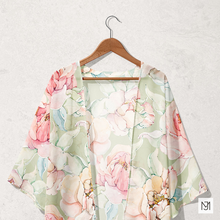 Watercolor Pastel Peonies pattern on a sheer kimono robe, hanging on a wood hanger against a plain wall.