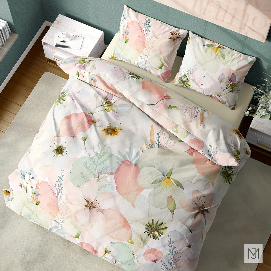 Bedroom with a duvet cover and pillows in the pressed flowers pattern, sage green patterned wallpaper, and a white nightstand