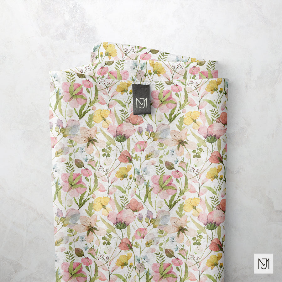 Spring Flowers pattern printed on folded fabric in a cream colorway, with a small brand tag stitched into one fold.