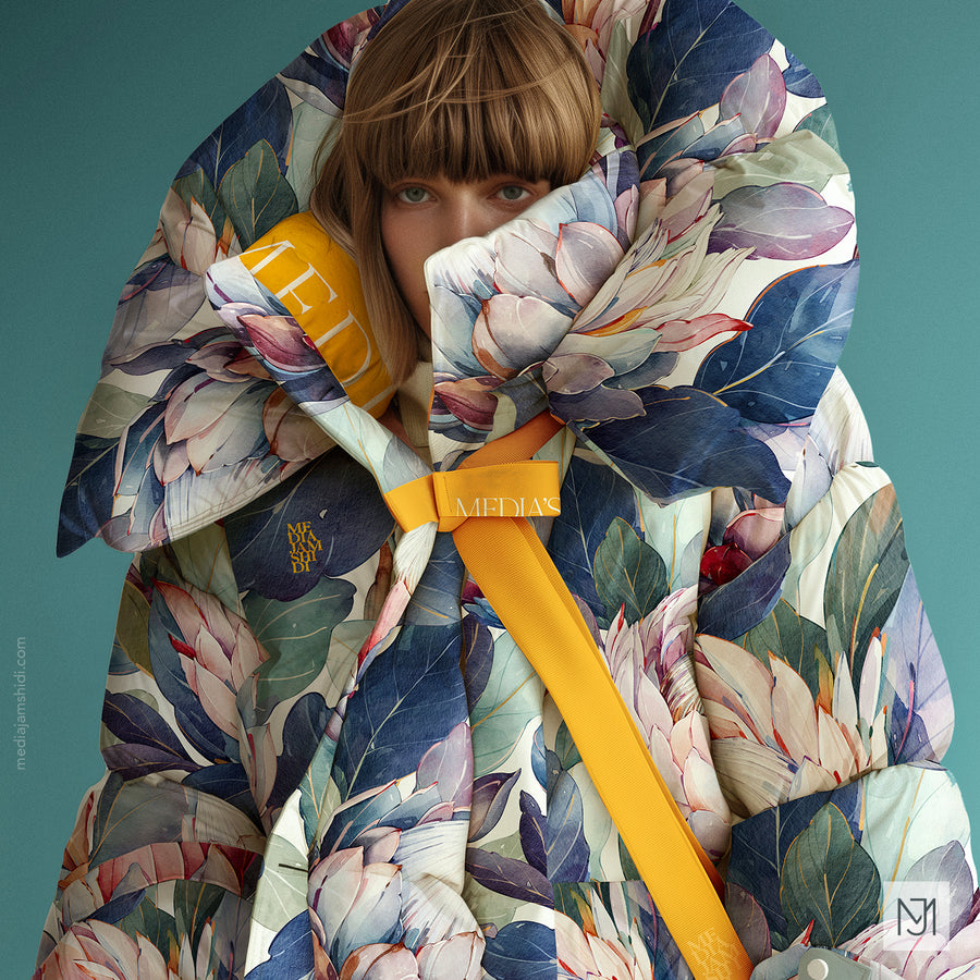 Cream puffer jacket in the protea pattern with a yellow strap and brand tag, worn tucked up over the wearer's face