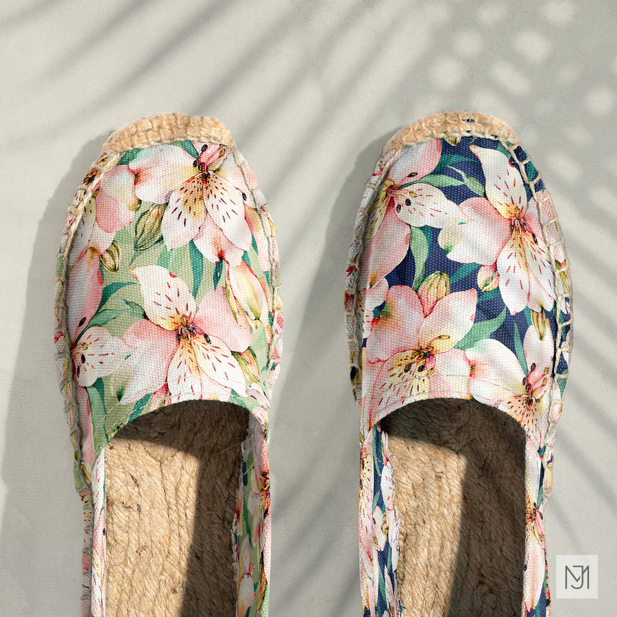 Alstroemeria pattern on a pair of espadrilles, one in a sage green colorway and one in navy.