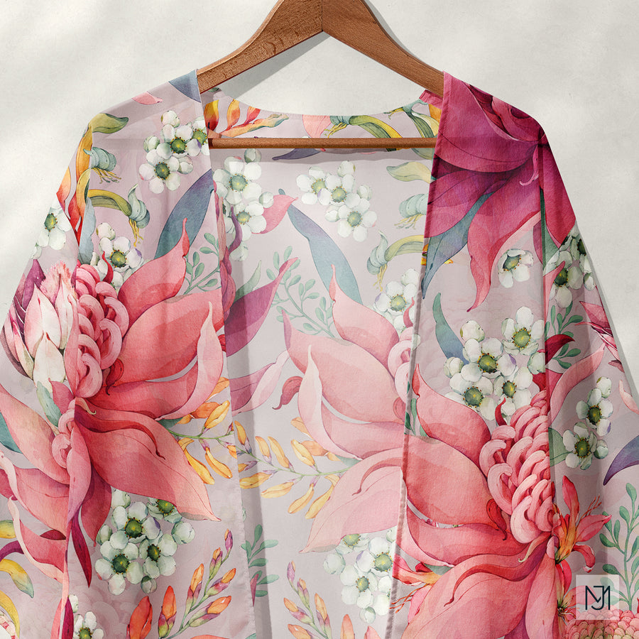 Kimono style robe on a wooden hanger in a blush pink colorway of the Australian Native Flowers pattern