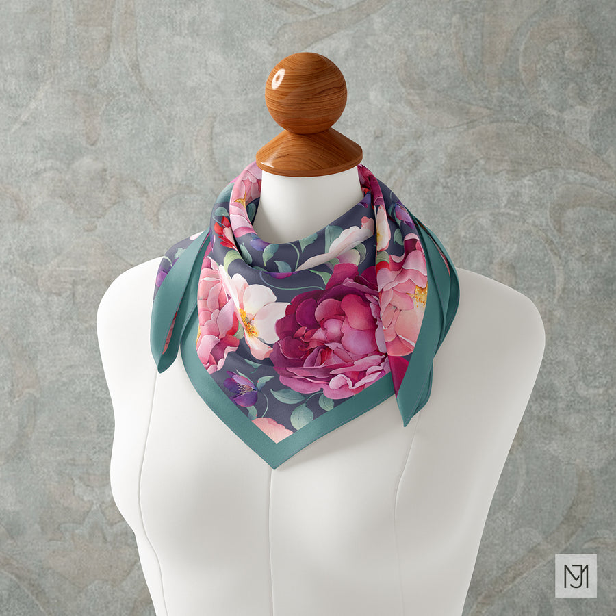 Scarf tied around a mannequin's neck in the Spring Garden rose pattern with a teal green border