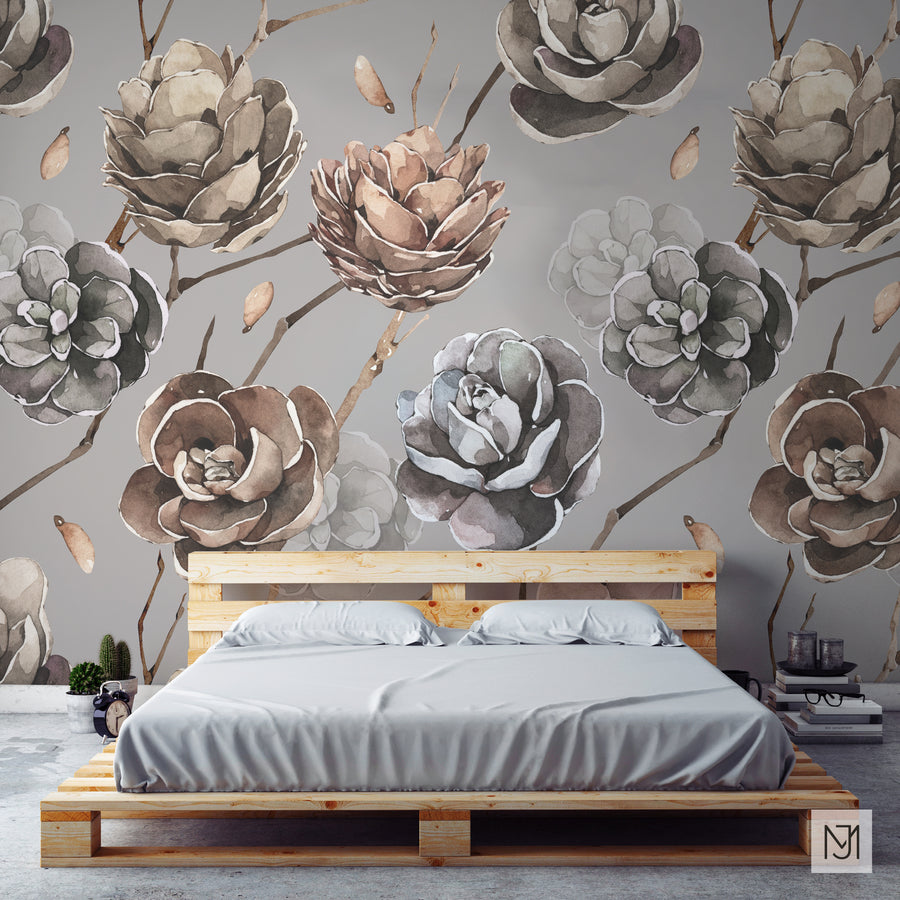 Winter Pine Cones pattern as a wallpaper mural behind a low wood pallet bed with gray bedding, small cacti, and a stack of books.