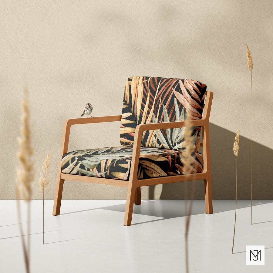 Tropical Leaves pattern upholstered on a wood-framed armchair in a dark navy colorway, with a small bird perched on the armrest.