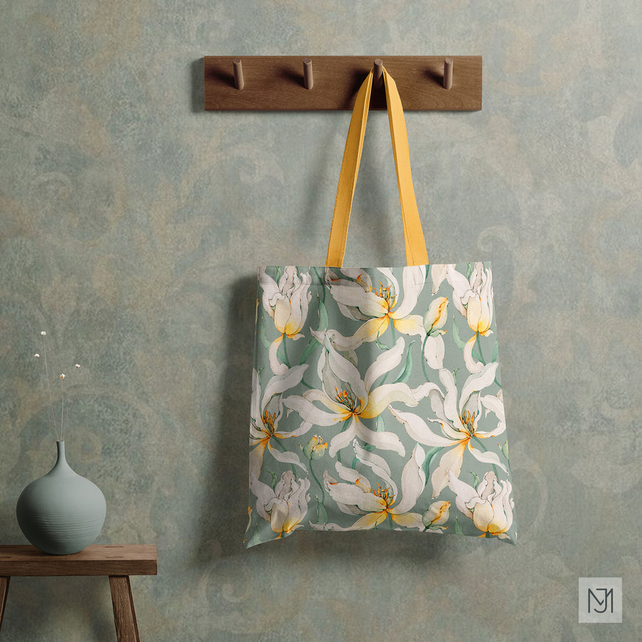 White Tulips pattern on a canvas tote bag with yellow straps, hanging from a wood wall hook.