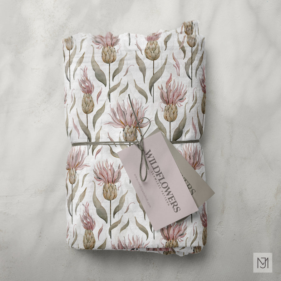 Wildflowers pattern printed on folded fabric tied into a bundle, in a cream colorway with a small brand tag.